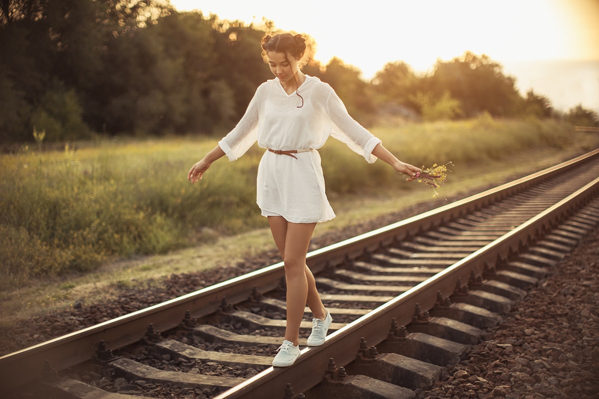 Woman balancing on train tracks