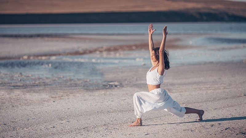 Woman doing yoga on beach
